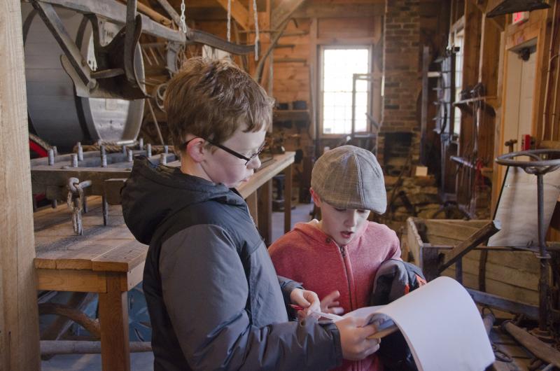 Andrew Porter and Andrew Scott scan the clues in the Mattapoisett Historical Society Carriage House. BY GEORGIA SPARLING